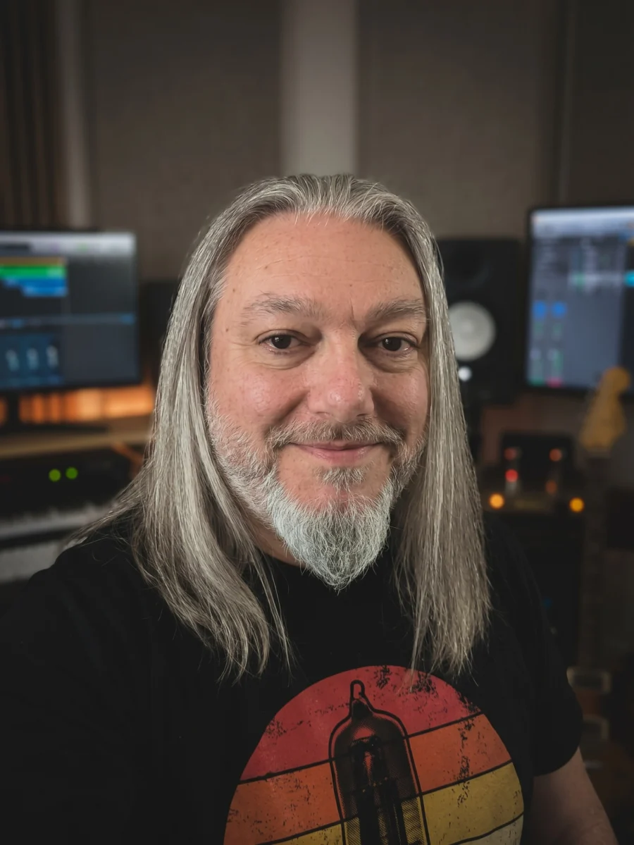 Jonny Reckless in his studio, smiling, in a T-shirt printed with a valve.